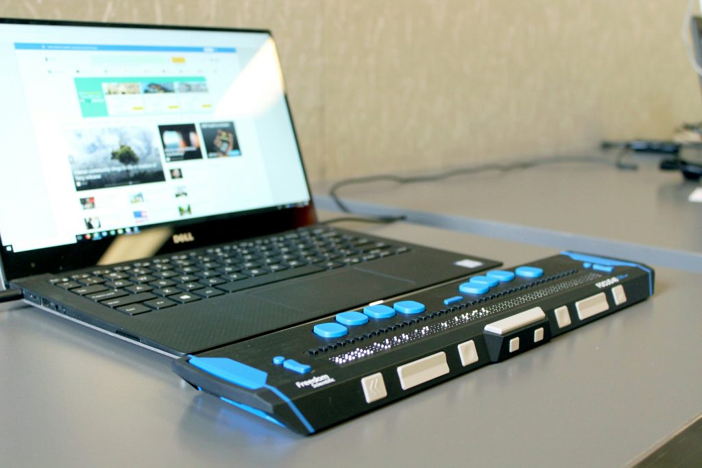 A braille keyboard for people with visual impairments, connected to a laptop