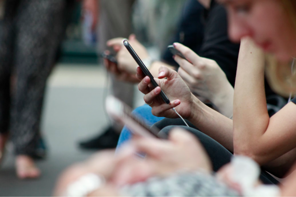 Picture of people holding phones on the train.